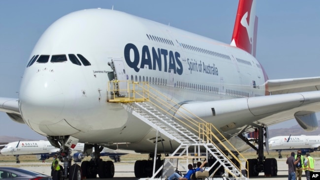 In this July 6, 2020, file photo, a Qantas Airbus A380 arrives in Victorville, Calif. Qantas said that once a virus vaccine becomes widely available, the carrier will likely require it before passengers can travel abroad or land in Australia. (AP Photo/Matt Hartman, File)