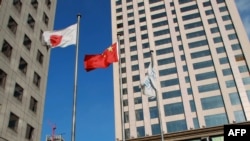资料照：大连市商业区楼群中飘扬的中日国旗。（2012年12月31日）