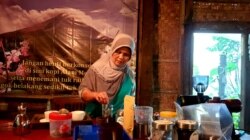 Bu Sari, pemilik warung kopi Merapi menyeduh kopi untuk tamu. (Foto:VOA/ Nurhadi)