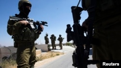 Tentara Israel berpatroli dalam operasi pencarian riga remaja yang hilang di kota Hebron, Tepi Barat (18/6).