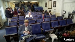 FILE - Glenn Thrush (L), chief White House political correspondent for the The New York Times, works in the briefing room after being excluded from a gaggle at the White House in Washington, February 24, 2017. 