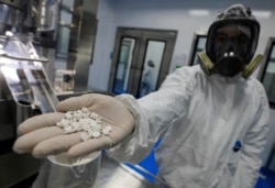 Seorang teknisi lab menunjukkan "Favipiravir", yang masih dalam pengujian untuk pengobatan virus corona (Covid-19) di Eva Pharma Facility di Kairo, Mesir, 25 Juni 2020. (Foto: Reuters)