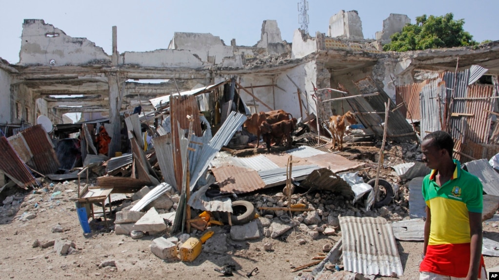 A man walks near destroyed buildings after a bomb blast in the capital city of Mogadishu, Somalia, Dec. 22, 2018. Police say a suicide car bomb exploded near the presidential palace killing and wounding a number of people.