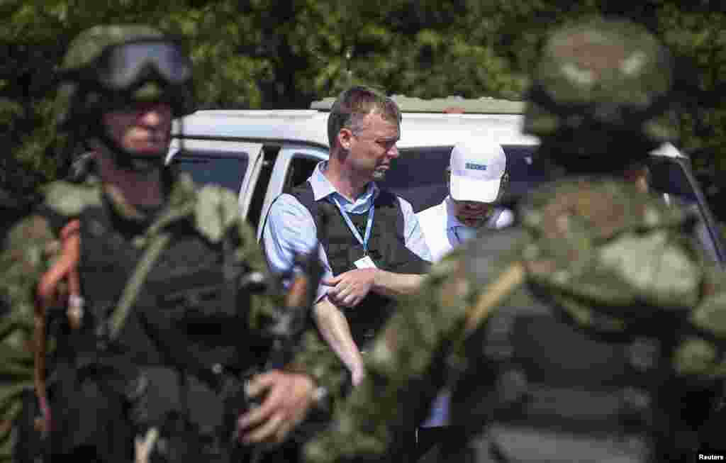 Alexander Hug (center), deputy head of OSCE, Europe&#39;s monitoring mission in Ukraine, stands next to armed pro-Russian separatists as the convoy makes its way to the MH17 crash site outside Donetsk, July 30, 2014.