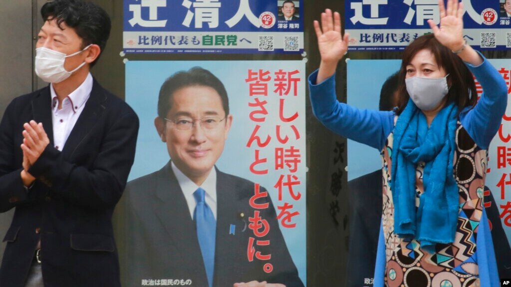 2021年20月27日将举行的一次竞选集会上，日本执政的自民党一个支持者在自民党领袖、首相岸田文雄的竞选广告前挥手。（美联社）(photo:VOA)