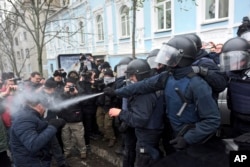 Police use tear gas as they clash with supporters of former Georgian president Mikheil Saakashvili in Kyiv, Ukraine, Dec. 5, 2017.