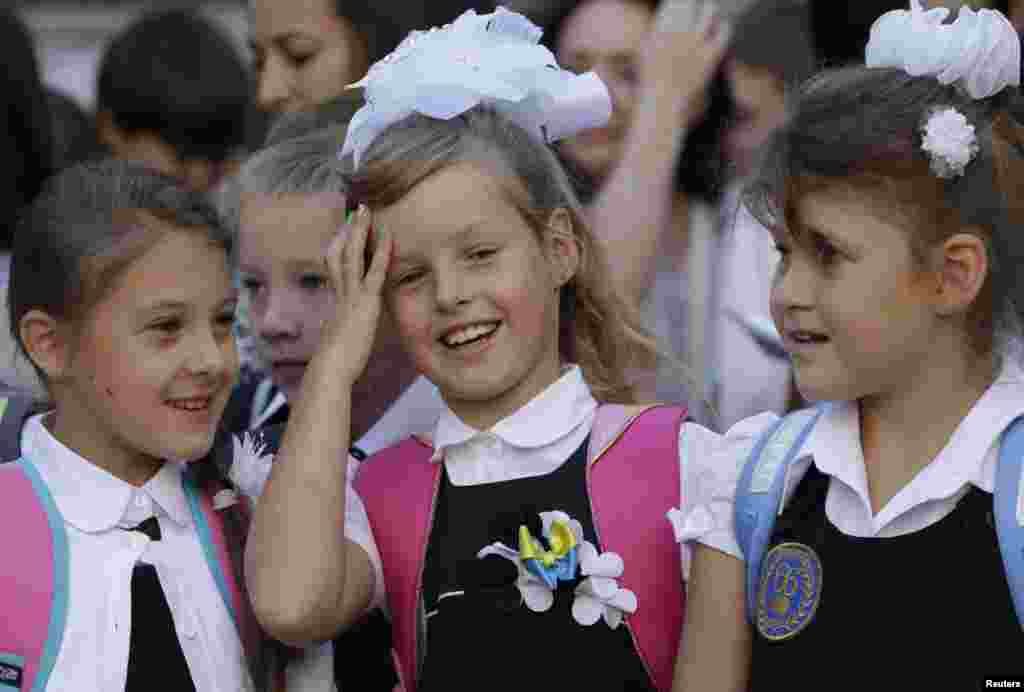 Schoolgirls talk during morning assembly in a school in the southern coastal town of Mariupol, Ukraine, Sept. 1, 2014. 