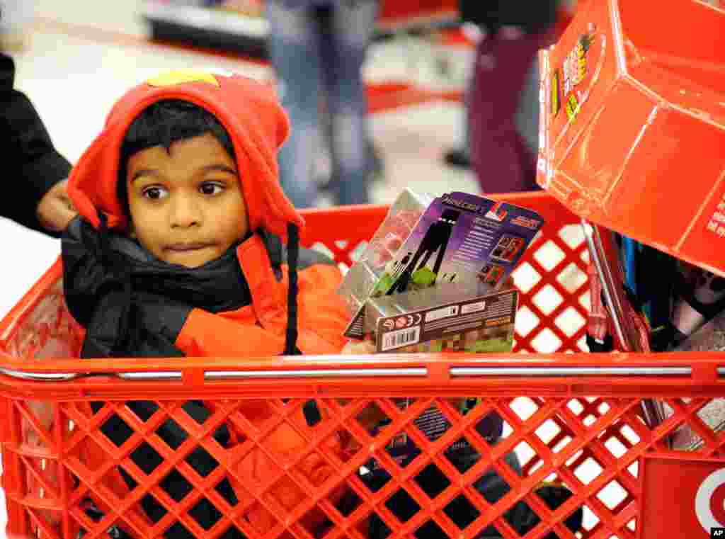 Jervis Benjamin, 8, dalam kereta dorong sementara orangtuanya berburu barang obral di toko Target, Minnetonka, Minnesota (28/11).