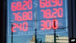 FILE - A sign shows currency exchange rates in Moscow, Russia, Aug. 21, 2015. Oil prices and economic sanctions have hit the country hard.