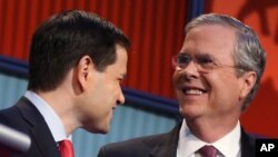 FILE - In this Aug. 6, 2015, photo, Republican presidential candidates Marco Rubio, left, and Jeb Bush talk during a break during the first Republican presidential debate at the Quicken Loans Arena in Cleveland, Ohio.
