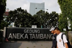 Pejalan kaki melintas di depan kantor PT Aneka Tambang, BUMN bidang pertambangan, di Jakarta, Indonesia, 28 November 2016.