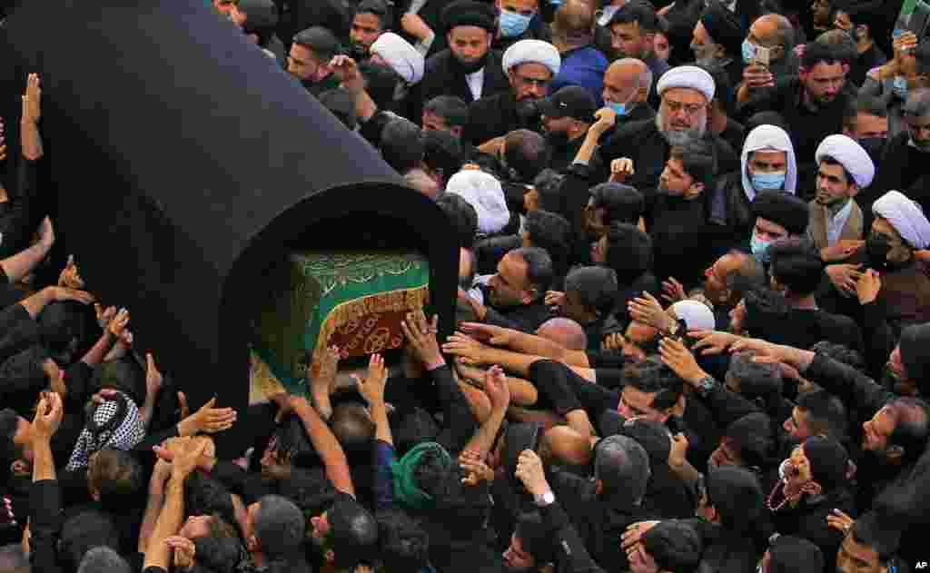 Mourners carry the coffin of Grand Ayatollah Sayyid Mohammed Saeed al-Hakim inside the holy shrine of Imam Ali during his funeral procession in Najaf, Iraq.
