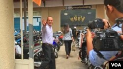 Moeun Tola, executive director of the Center for Alliance of Labor and Human Rights (CENTRAL), waved to reporters as he enters the Phnom Penh Municipal Court, Cambodia, May 25, 2018. (Hul Reaksmey/VOA Khmer)