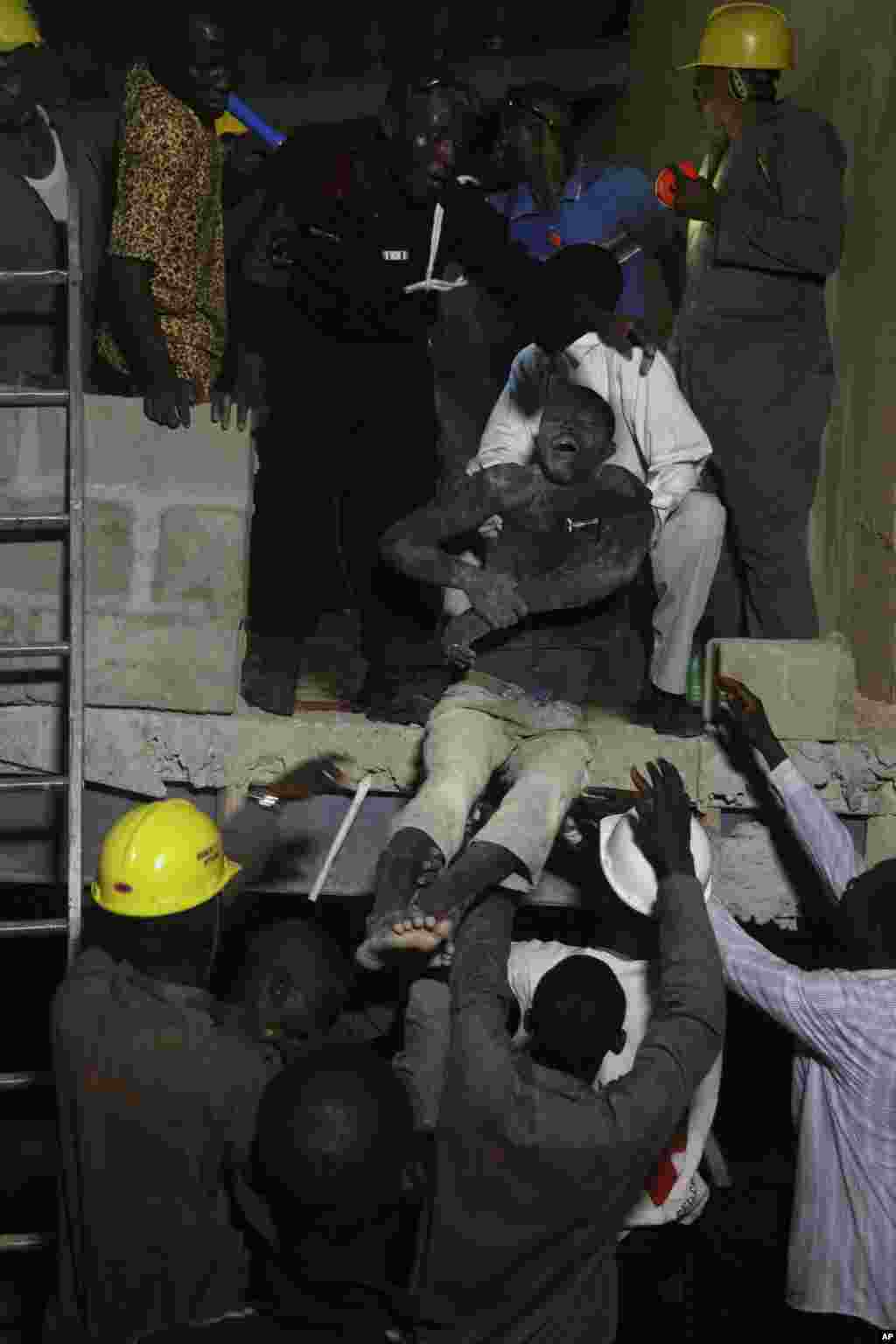 Rescue workers carry a survivor from the rubble of a building under construction which collapsed in Lagos, Nigeria, Nov, 4. 2013. 
