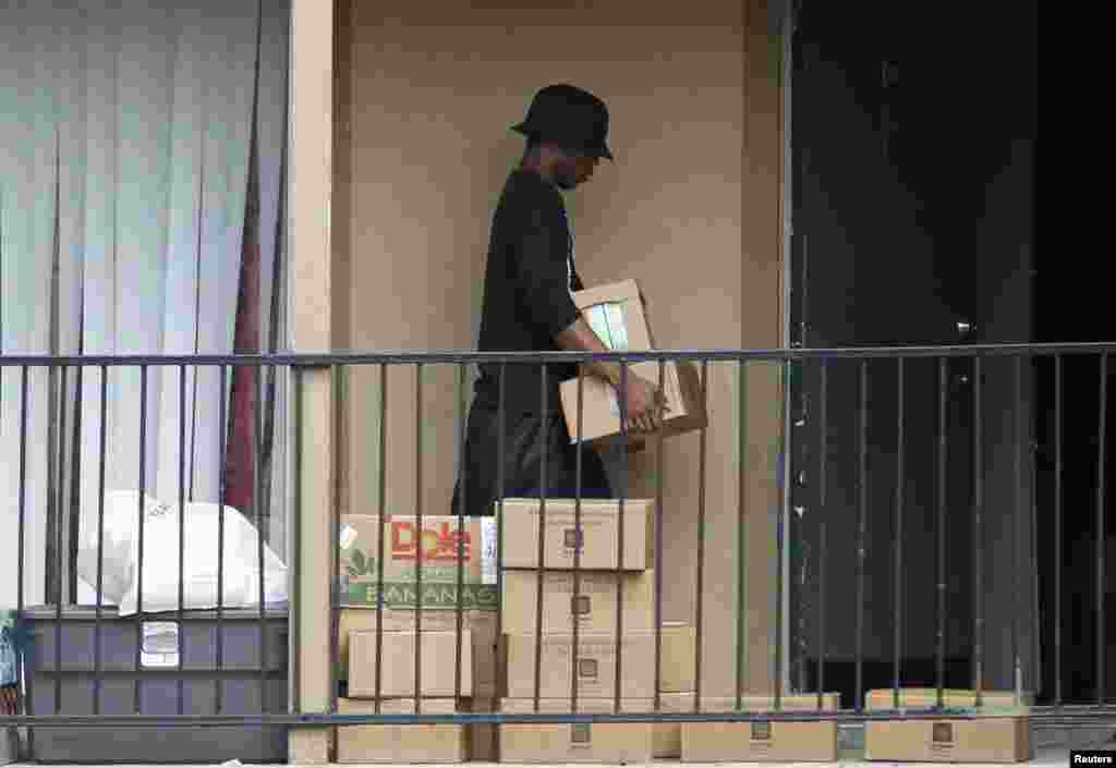 A man emerges from the apartment unit to get boxes of food delivered by the Red Cross and the North Texas Food Bank in The Ivy Apartments complex in Dallas, Texas Oct. 2, 2014. 