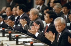 FILE - From left: Khmer Rouge factions leaders, Im Chuun Lin, Cambodian Premier Hun Sen, Dith Munty, Cambodian Prince Norodom Sihanouk, Ieng Mouly and Khieu Samphan, applaud 23 October 1991 in Paris after signning the peace treaty which ended dacades of civil war.