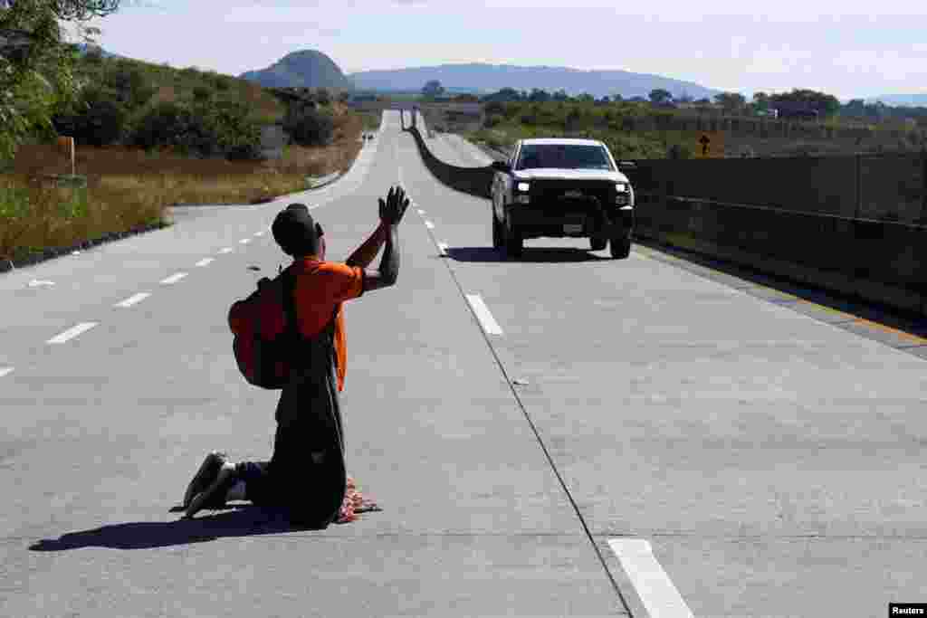 A migrant, part of a caravan of thousands traveling from Central America to the United States, hitchhikes on a road near Guadalajara, Mexico, November 13, 2018.