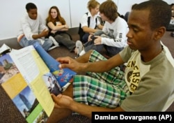 A high school student from Arleta, California reads information about possible college choices at the National College Fairs event held in Pasadena, California in 2009.