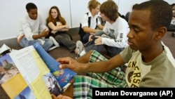 A high school student from Arleta, California reads information about possible college choices at the National College Fairs event held in Pasadena, California in 2009.