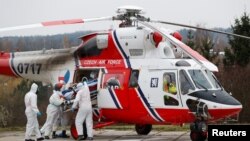 Medical workers transport a coronavirus disease (COVID-19) patient, who is being transferred from a Brno hospital by a Czech Air Force helicopter, in Prague, Czech Republic, Nov. 25, 2021.