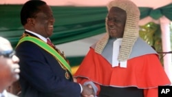 FILE: Zimbabwean President Emmerson Mnangagwa,left, is congratulated by Chief Justice Luke Malaba after taking his oath during his inauguration ceremony at the National Sports Stadium in Harare, Sunday, Aug. 26, 2018. 