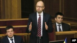 Ukrainian Prime Minister Arseniy Yatsenyuk, center, reacts after surviving a vote of no confidence, in Parliament in Kyiv, Ukraine, Tuesday, Feb. 16, 2016.