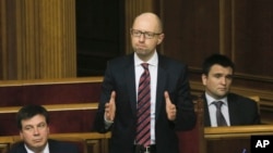 FILE - Ukrainian Prime Minister Arseniy Yatsenyuk, center, reacts after surviving a vote of no confidence, in Parliament in Kyiv, Feb. 16, 2016. Yatsenyuk said April 10, 2016, he is resigning, opening the way for a new government to be formed in an effort to end Kyiv's political crisis.