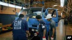 FILE - Employees work at a General Motors Egypt joint venture truck plant, just outside Cairo, Egypt. 