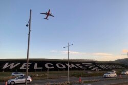 Sebuah tanda raksasa yang dilukis di dekat landasan utama Bandara Internasional Wellington, di Wellington, Selandia Baru menyambut para pelancong mudik, Senin, 19 April 2021.