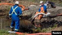 Emergency crews work to clean up an oil spill near Interstate 40 in Mayflower, Arkansas. An Exxon Mobil pipeline carrying Canadian crude oil was shut off after a ruptured on Friday causing an evacuation of 22 homes, Mar. 31, 2013.