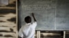 FILE - In a photo provided by UNESCO, a Congolese boy writes on a blackboard at a school near the town of Kitschoro in the conflict-stricken east of the Democratic Republic of Congo, May 15, 2012. 