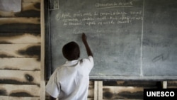 FILE - In a photo provided by UNESCO, a Congolese boy writes on a blackboard at a school near the town of Kitschoro in the conflict-stricken east of the Democratic Republic of Congo, May 15, 2012.
