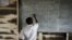 FILE - In a photo provided by UNESCO, a Congolese boy writes on a blackboard at a school near the town of Kitschoro in the conflict-stricken east of the Democratic Republic of Congo, May 15, 2012. 