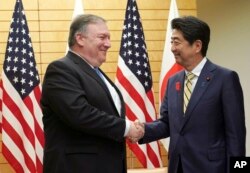 El secretario de Estado de EE.UU., Mike Pompeo (izq.) se saluda con el primer ministro japonés Shinzo Abe, antes de reunirse en Tokio, el sábado 6 de octubre de 2018.