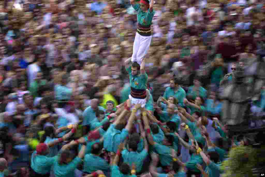 Participants walk maintaining a human tower or &quot;Castellers&quot; during the Saint Merce celebrations in San Jaume square in Barcelona, Spain.