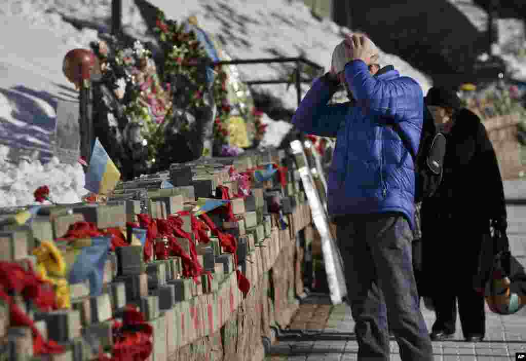 A man looks at pictures of victims of the Maidan Square protests, which happened nearly one year ago, from February 20-22,&nbsp; placed as a commemoration in Kyiv, Ukraine, Feb. 17, 2015.