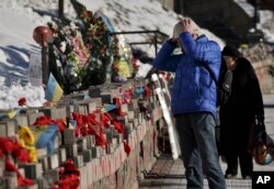 Một người đàn ông xem những bức ảnh các nạn nhân thiệt mạng trong cuộc biểu tình tại quảng trường Maidan ở Kyiv, Ukraine, 17/2/2015.