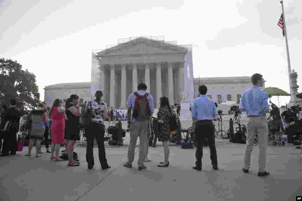 지난 24일 미국 워싱턴 DC 연방대법원 앞에서 동성 결혼 금지법 합헌 여부에 대한 연방대법원의 판결을 기다리는 사람들.