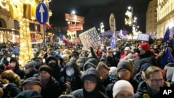 Ljudi demonstriraju nakon što je poljski parlament odobrio nacrt zakona za koji se smatra da ograničava slobodu medija, u Varšavi, Poljska, 19. prosinca 2021.
