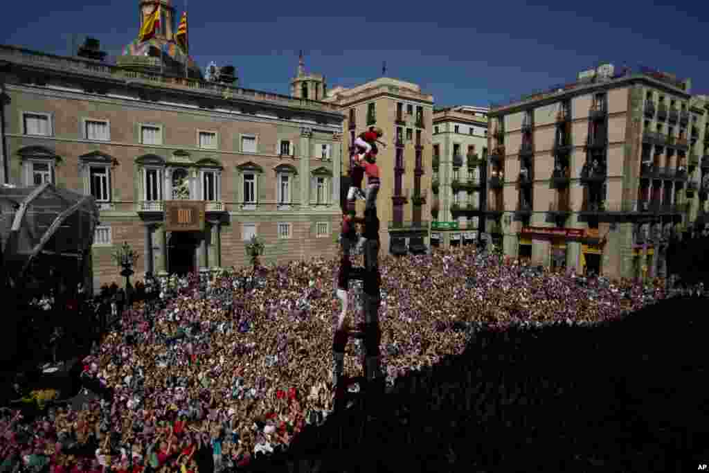 Anggota menara manusia, atau Castellers, Joves Xiquets de Valls membentuk menara manusia dalam perayaan Saint Merce di lapangan San Jaime di Barcelona, Spanyol.