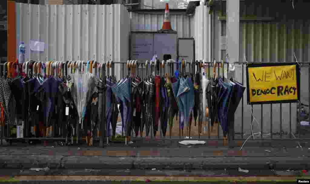 Os chapéus-de-chuva usados pelos manifestantes pendurados nas grades junto à principal estrada que conduz ao centro financeiro de Hong Kong, Set. 30, 2014. 