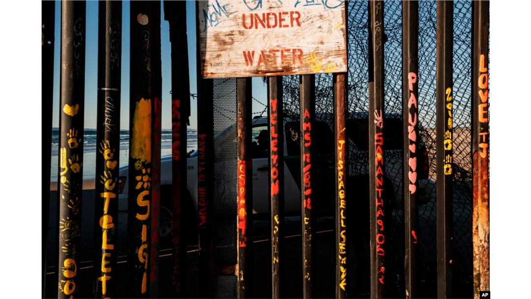 A border patrol office inside his vehicle guards the border fence at the U.S. side of San Diego, Calif., as seen from Tijuana, Mexico, Jan. 2, 2019.