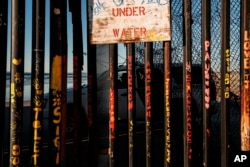 A border patrol officer inside his vehicle guards the border fence on the U.S. side of San Diego, Calif., as seen from Tijuana, Mexico, Jan. 2, 2019.