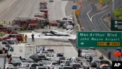 Bomberos y trabajadores de emergencia rodean el Cessna 310 que se estrelló en la Interestatal 405, cerca de la pista del aeropuerto John Wayne, en Costa Mesa, California. Junio 30, 2017