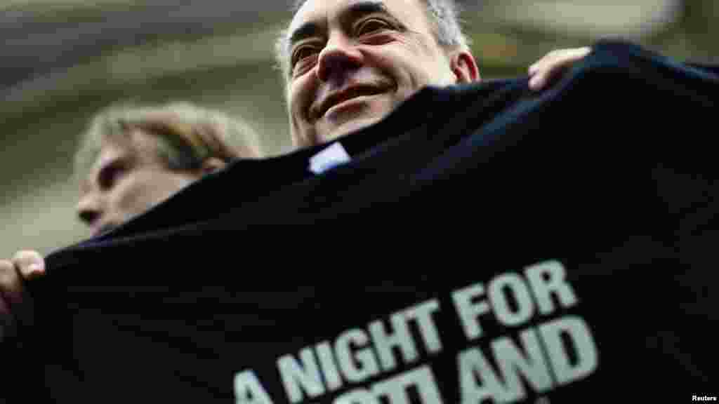 Scotland's First Minister Alex Salmond holds a T-shirt promoting a concert being held in support of a "Yes" vote, in Edinburgh, Scotland, Sept. 14, 2014. 