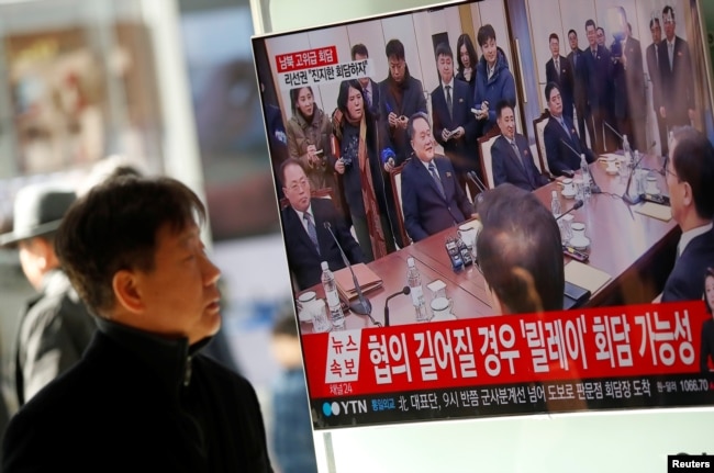 A man watches a TV broadcasting a news report on a high-level talks between the two Koreas at the truce village of Panmunjom, in Seoul, South Korea, Jan. 9, 2018.