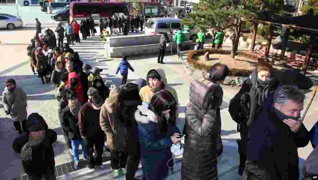 South Koreans wait in line to cast their votes in a presidential election at a polling station in Seoul, South Korea, December 19, 2012.