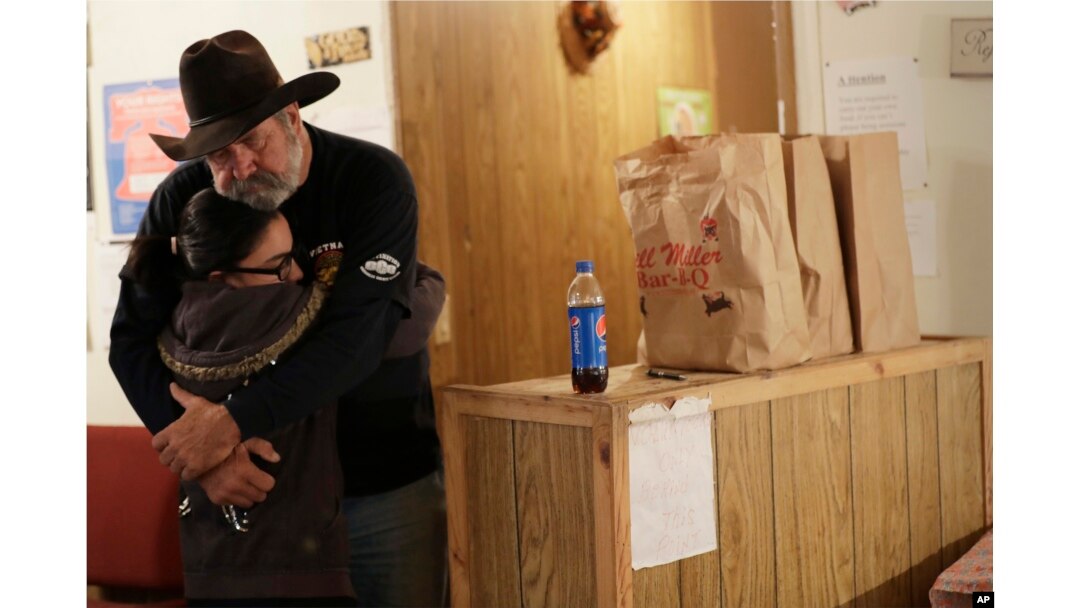 Rod Green, right, hugs a friend at By His Grace, a food pantry affiliated with Sutherland Springs Baptist Church in Sutherland Springs, Texas, Nov. 10, 2017.