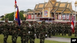 Cambodian Army soldiers stand as they practice in front of Royal Palace ahead of the country's 65th Independence Day, in Phnom Penh, Cambodia, Wednesday, Nov. 7, 2018. (AP Photo/Heng Sinith)