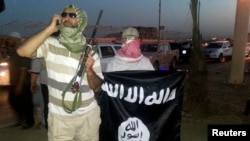 지난해 6월 이라크 모술에서 이슬람 수니파 무장단체 ISIL 요원이 무기와 깃발을 들고 있다. (자료사진)